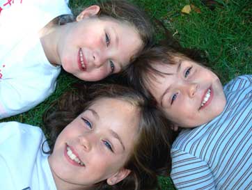 Oviedo Dentist Group of children lying on grass smiling